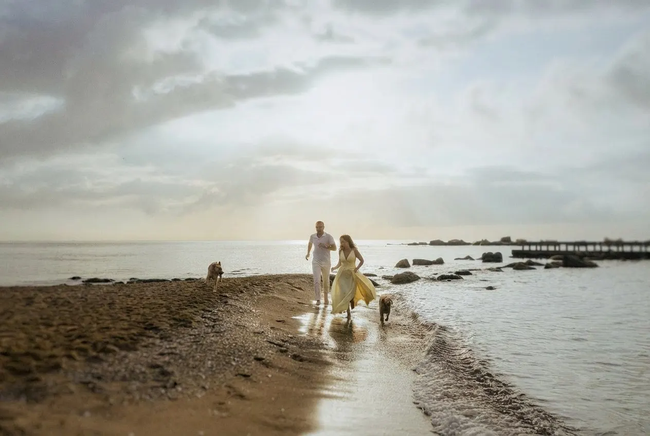Gabrielle and Joe walking the shore with the dogs